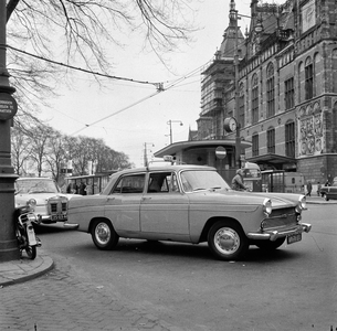 150081 Afbeelding van taxi's voor het N.S.-station Amsterdam C.S. te Amsterdam.